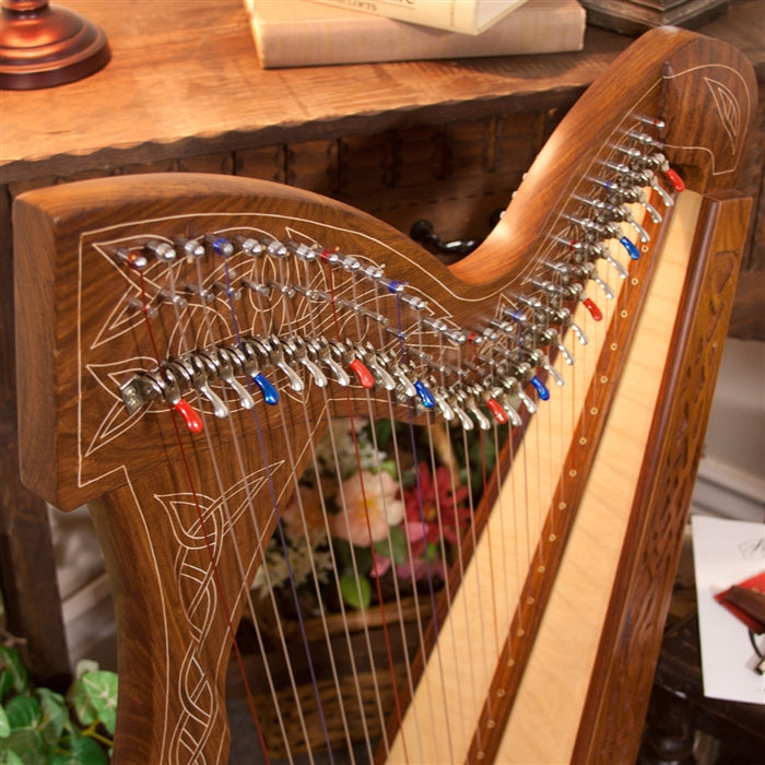 Close-up of upgraded Chelby levers with red and blue end caps, Roosebeck 29 String Minstrel Harp (Celtic Knotwork Carved Inlay, Extra String Set)